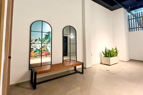 Espejos de arco y banco de madera en el área social