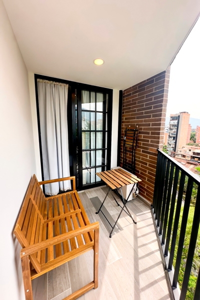 Balcón privado con mesa y sillas de madera para café